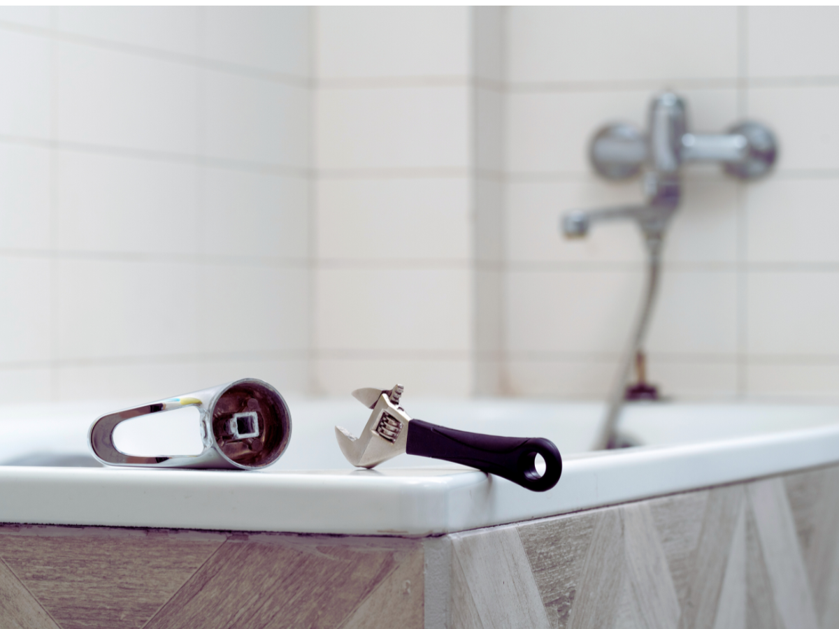 wrench and tub handle laying on top of tub