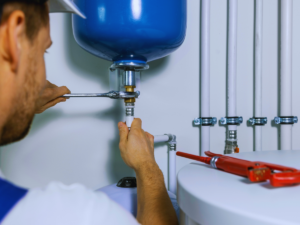 Plumber installing an expansion tank for water heater